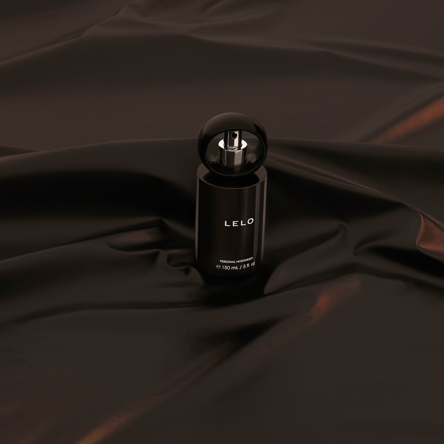 Bouteille élégante de lubrifiant intime LELO 150ml posée sur une soie luxueuse, disponible chez Oh My God'Z pour une expérience douce et sensuelle.