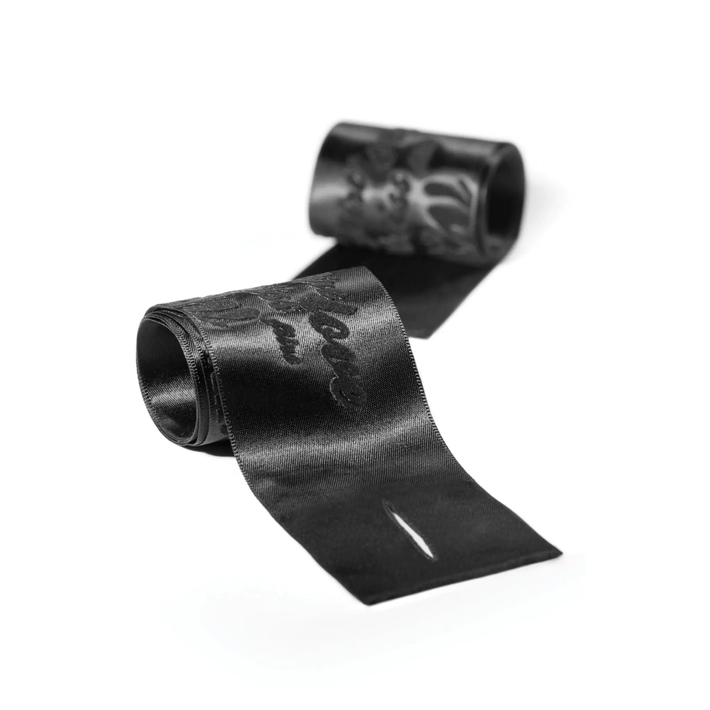 Menottes en ruban satiné noir élégant avec des détails de style baroque, une invitation à l'exploration sensuelle par bijoux indiscrets, disponibles chez Oh My God'Z pour des moments de complicité raffinée.