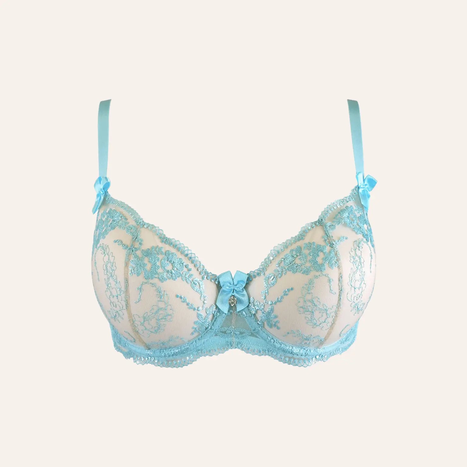 Gros plan sur le soutien-gorge en dentelle bleu ciel Axami, proposé par Oh My God'Z, avec ses motifs floraux délicats, un nœud décoratif et un bijou central. Parfait pour une lingerie haut de gamme mêlant style romantique et sensualité.