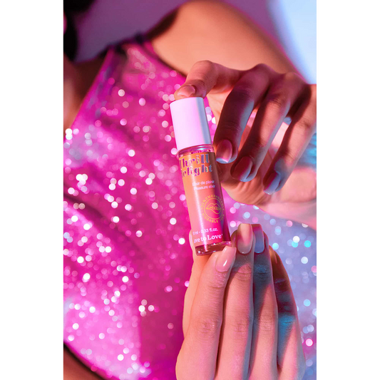 Élixir de plaisir Thrill Delight et son étui présentés sur podium lumineux rose et orange - Oh My God'Z
