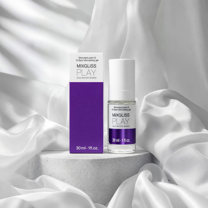 Flacon et etui violets du gel stimulant point G Mixgliss Play 30 ml poses sur socle beton et tissu blanc - Oh My God'Z