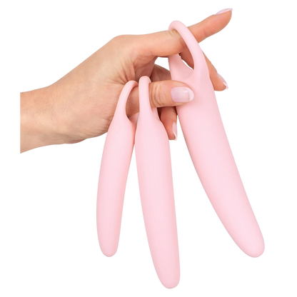 Main tenant trois dilatateurs vaginaux progressifs Oh My God'Z en silicone rose avec anneau de préhension.