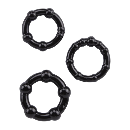 Trois cockrings noirs souples en TPR a billes de stimulation, de diametres differents, poses a plat - Oh My God'Z